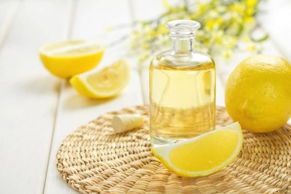 Лимонное масло в бутылке и лимоны