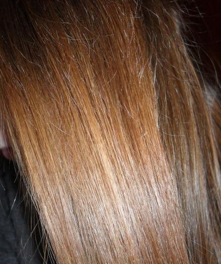 Волосы девушки, которая использует персиковое масло для волос в качестве самостоятельной маски