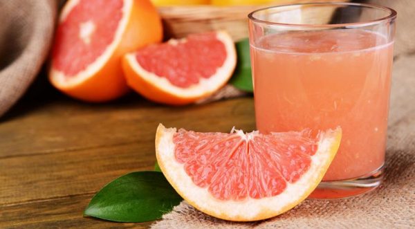 Сок грейпфрута в прозрачном стакане и фрукты