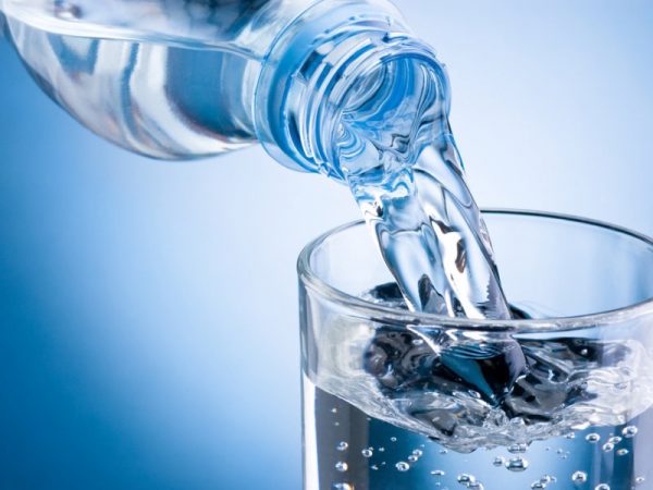 Минеральная вода льётся из бутылки в стакан