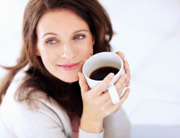 Женщина пьёт кофе